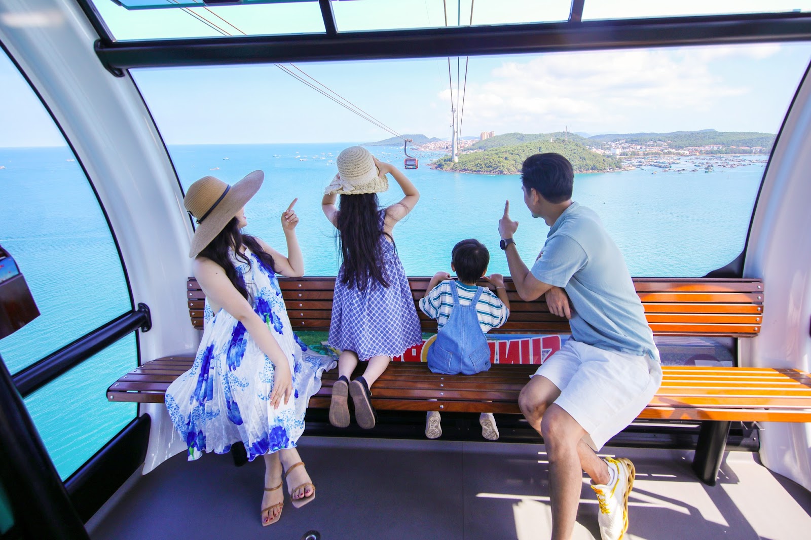 Du khách chiêm ngưỡng khung ảnh biển xanh rộng bao la từ cabin cáp treo.