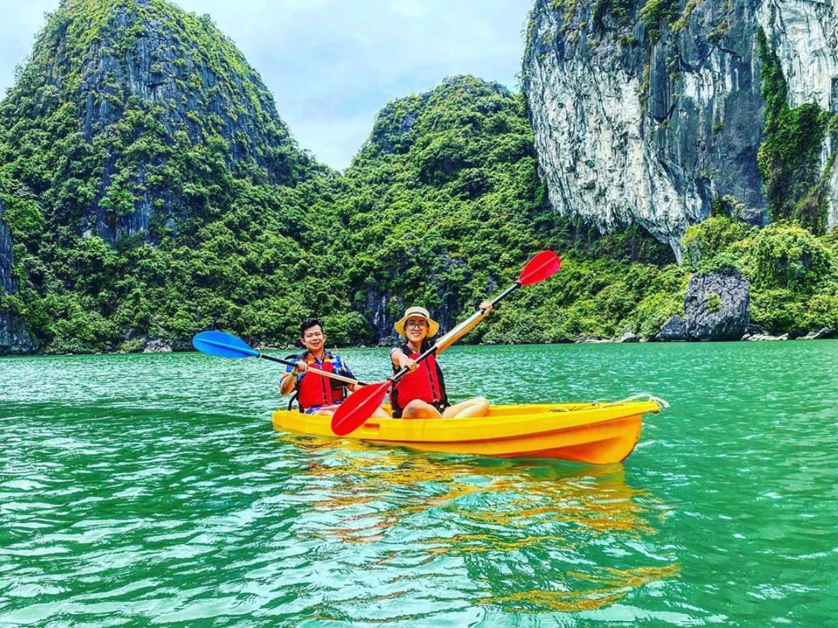 Du khách check-in trên tàu mái chèo khi tham quan Hòn Đỉnh Hương.