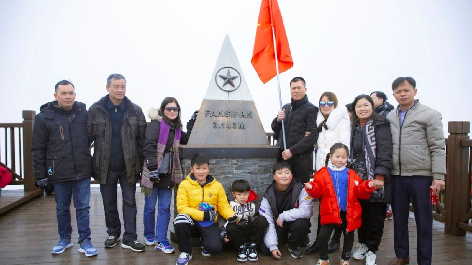 Du khách rạng rỡ check-in bên đỉnh Fansipan.