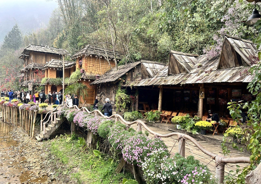 A peaceful village nestled beside high mountains and a gentle stream.