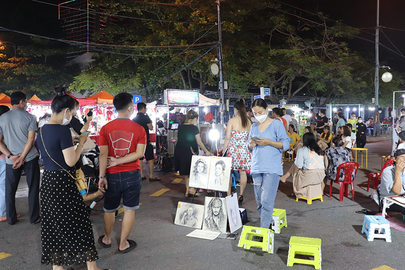 Du khách tới chợ đêm Sơn Trà có thể tham gia hoạt động phác họa chân dung người, viết thư pháp (Nguồn: laodong.vn)