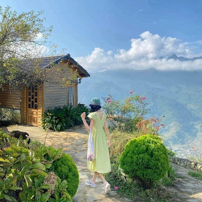 Quay lưng, tay cầm giỏ xách và bước đi từ tốn qua những bụi cây tươi tốt của Rock Garden Homestay (Nguồn: Trần Quang Minh)