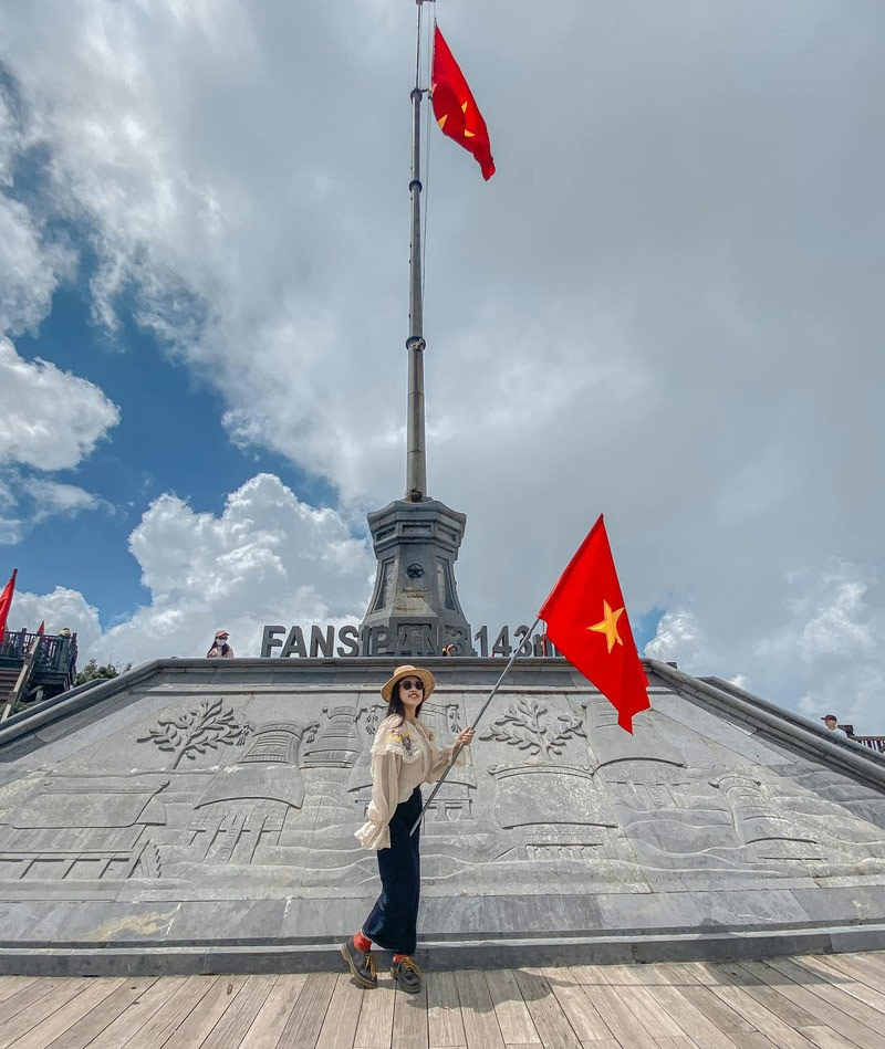 Du khách nữ chụp ảnh tại cột cờ Fansipan