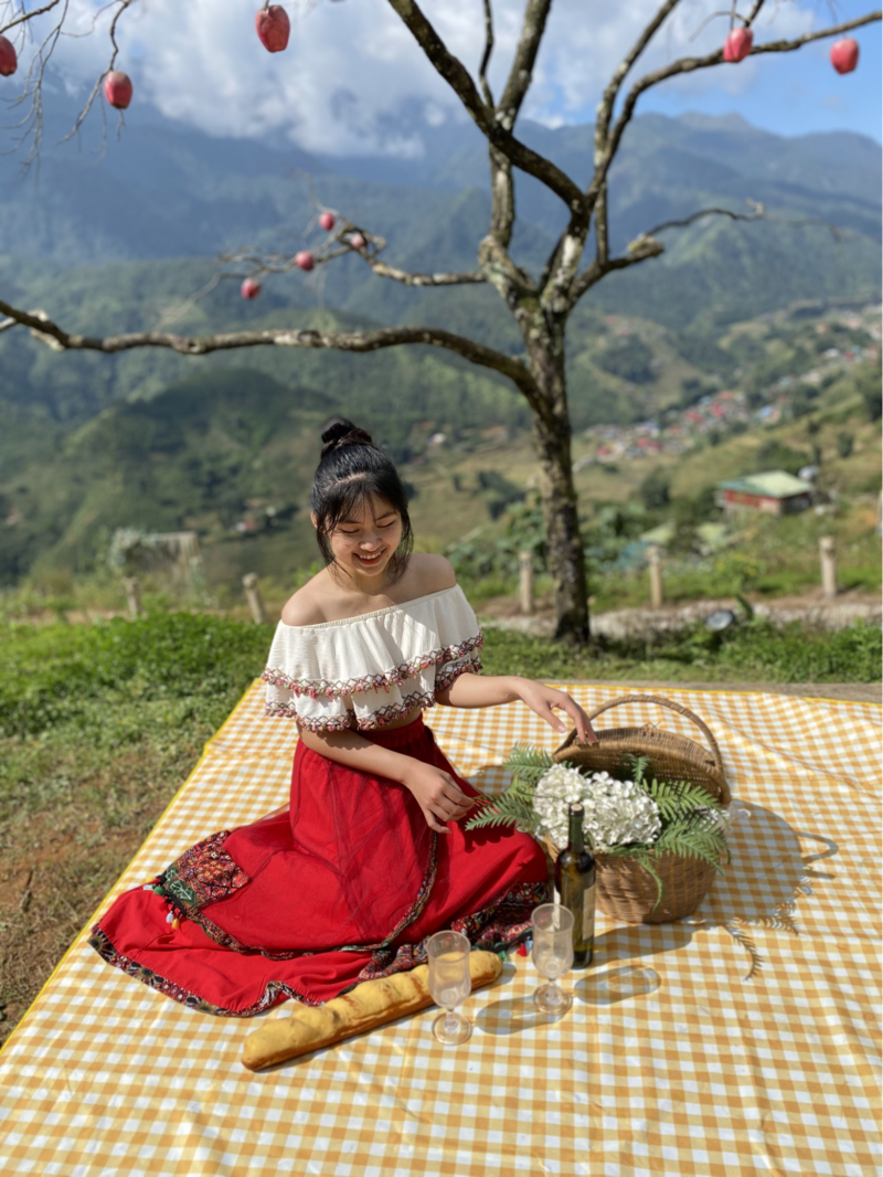 Giỏ hoa, bánh mì và rượu vang được bày trí đẹp mắt trên tấm vải caro màu vàng (Nguồn: An Jun)