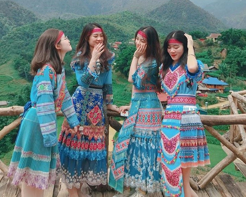 Nhóm du khách nữ chụp ảnh trong trang phục của người đồng bào dân tộc