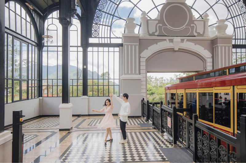 Cặp đôi trẻ check-in bên cạnh đường ray tàu hỏa của ga Mường Hoa