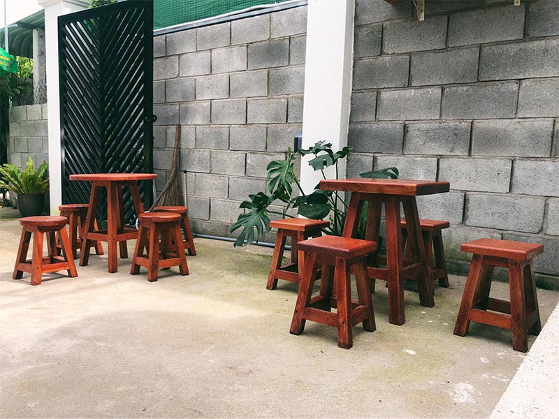 Lối vào quán đặt một vài bộ bàn ghế gỗ