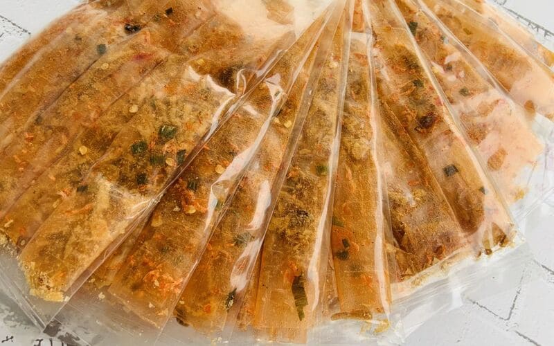 Những gói bánh tráng phơi sương dẻo tôm ngập trong muối ớt, hành phí và tôm khô được nhiều du khách mua về làm quà 