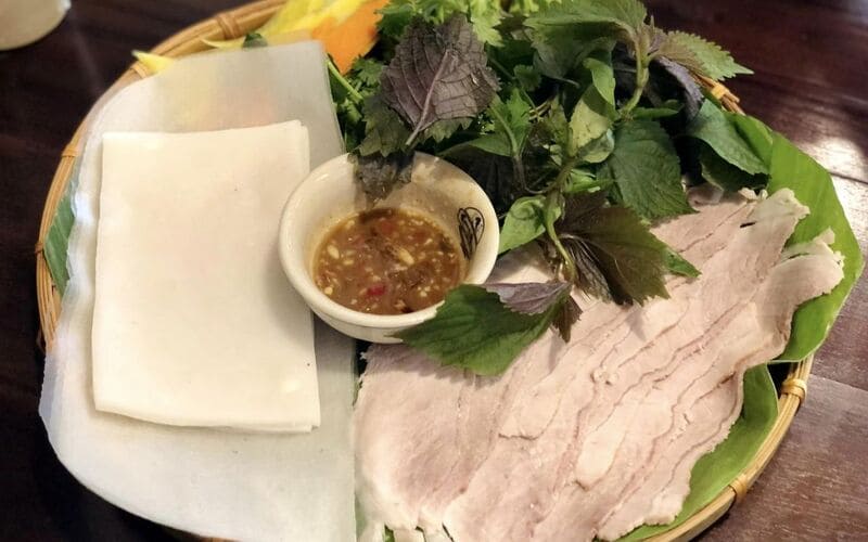 Một suất bánh tráng cuốn Tây Ninh bao gồm bánh tráng phơi sương Trảng Bàng, thịt lợn thái mỏng và rất nhiều loại rau rừng 