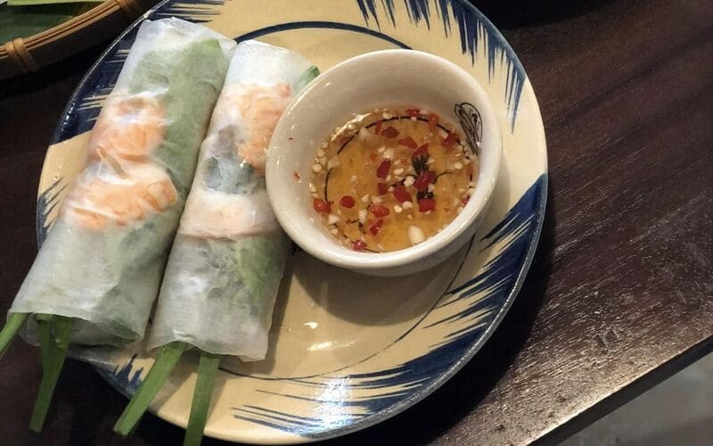 Những lát bánh tráng được cuốn cùng thịt lớn và rất nhiều loại rau, chấm ngập trong nước mắm chua ngọt