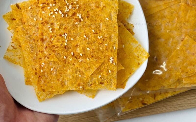 Những miếng bánh tráng mỏng được cắt nhỏ phủ thêm phô mai vàng ươm 