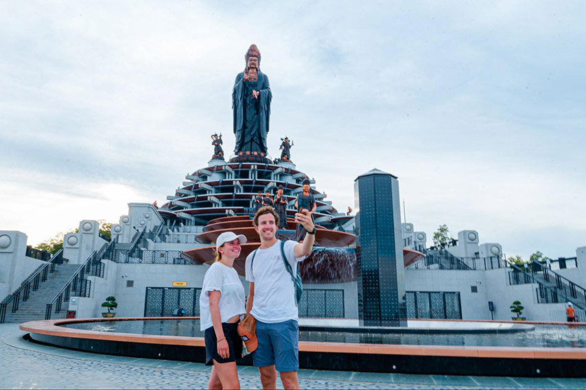 Du khách nước ngoài check in dưới chân tượng Phật 