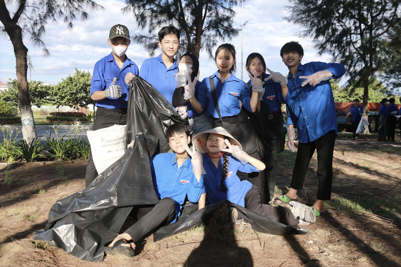 Tình nguyện viên hăng say nhặt rác bên bờ biển 