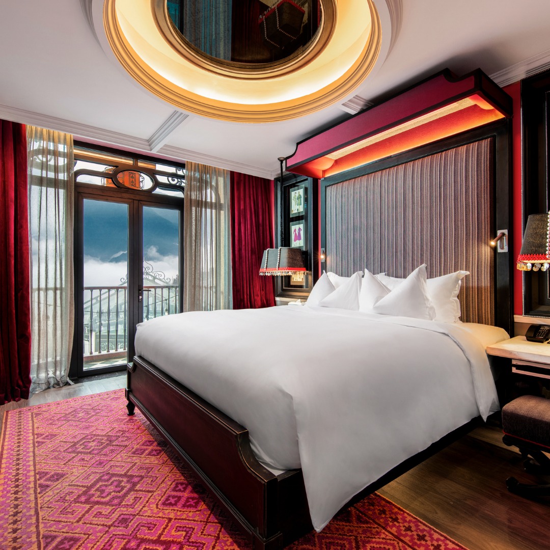 Deluxe Suite với nội thất tông đỏ ấm áp và tinh tế.