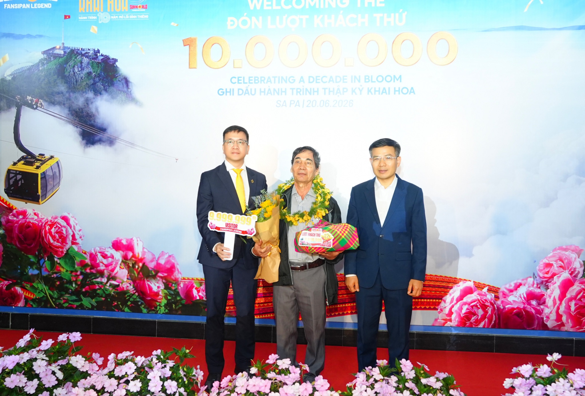Ông Nguyễn Anh Vũ – Phó Tổng quản lý Sun World Fansipan Legend (bên trái) và ông Đỗ Văn Tân - Bí Thư Đảng ủy - Chủ tịch HĐND Xã Tả Van (bên phải) trao quà cho vị khách thứ 9.999.999.