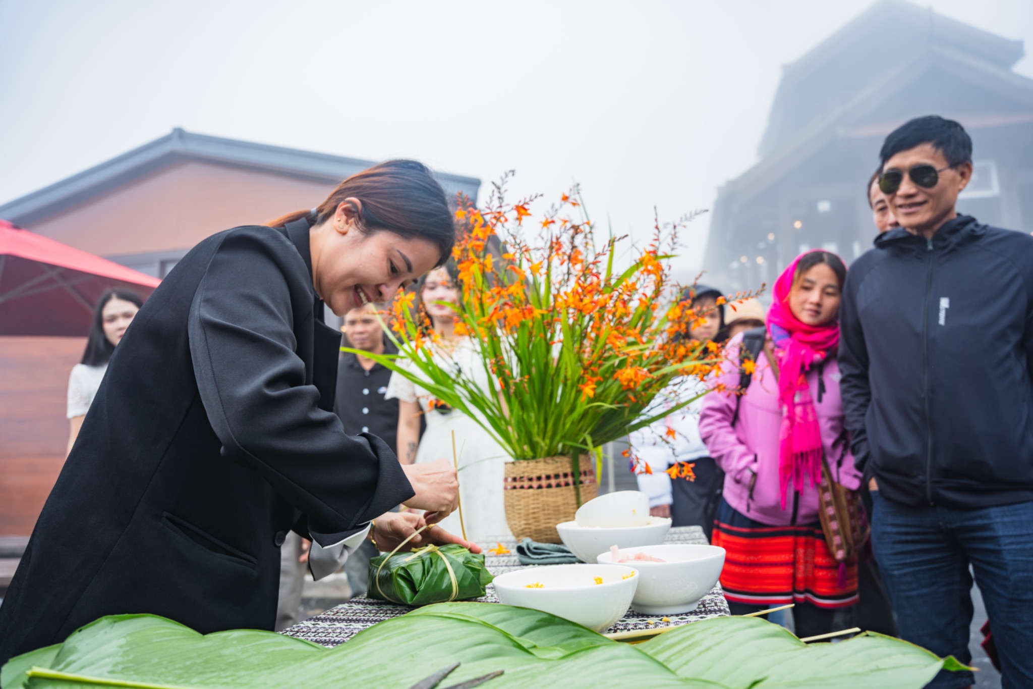 Du khách tham gia thi gói bánh chưng và cắm hoa dơn thóc.