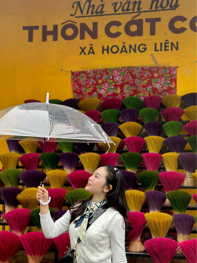 Du khách chụp ảnh với phông nền là những bó nhang thơm