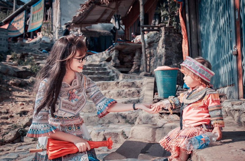 Bức ảnh chụp lại khoảnh khắc du khách nữ giao lưu cùng em bé người đồng bào