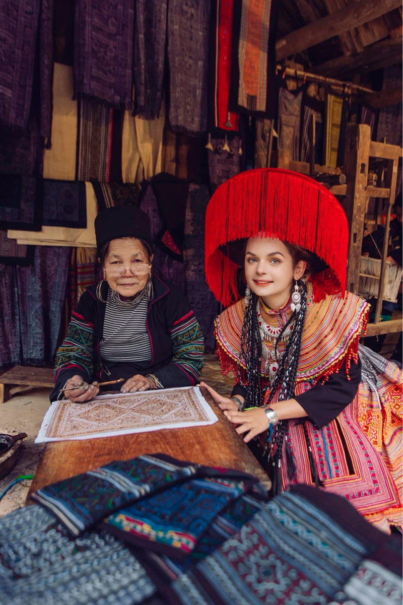 Du khách nước ngoài thích thú chụp ảnh cùng nghệ nhân vẽ tranh sáp ong