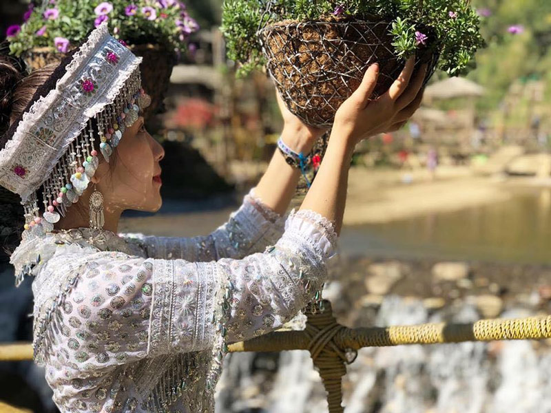 Du khách chụp ảnh cùng giỏ hoa trên thành cầu