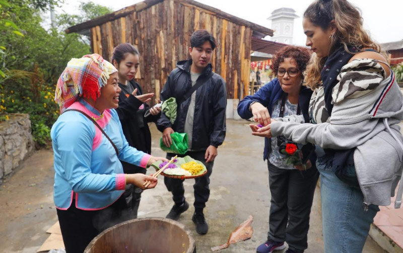 Du khách nước ngoài thích thú khi thưởng thức xôi ngũ sắc tại Bản Mây