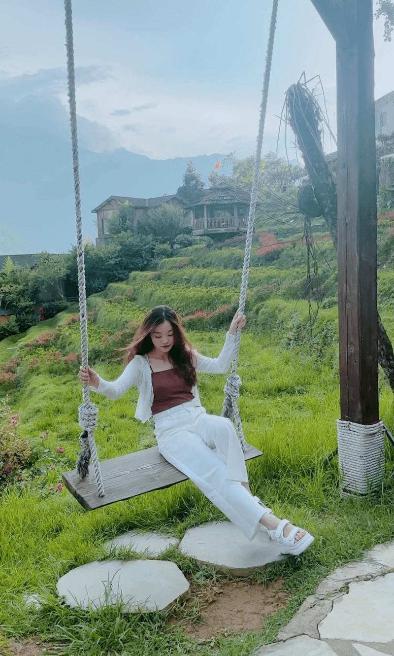 Đi Sa Pa mùa hè mặc phong cách nữ tính với áo hai dây khoác bên ngoài một chiếc áo mỏng, quần dài ống rộng và xăng đan