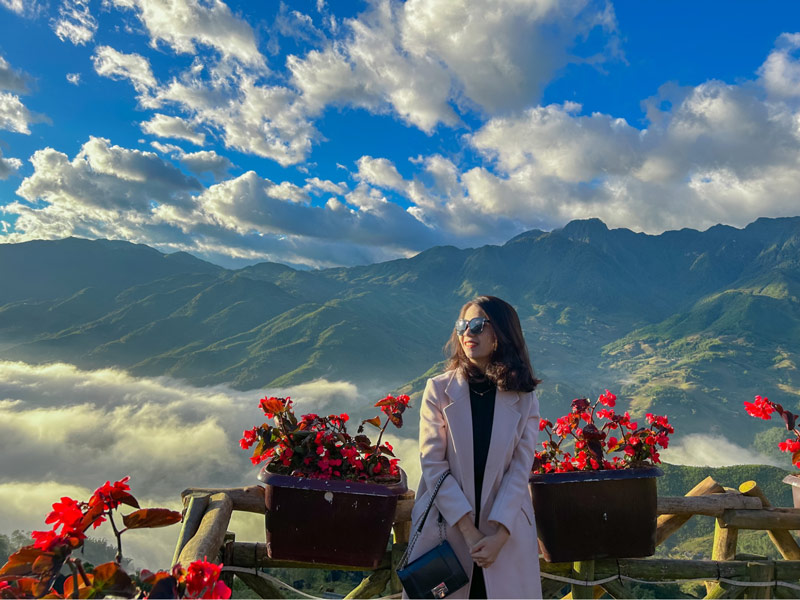 Người đứng quay lưng về biển mây, căn góc chụp chính giữa, chỉ lấy nửa người phía trên để bắt trọn khung hình 