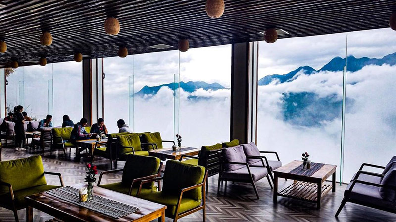 Ngắm nhìn những đám mây trắng xoá bên ngoài cửa kính của quán cà phê