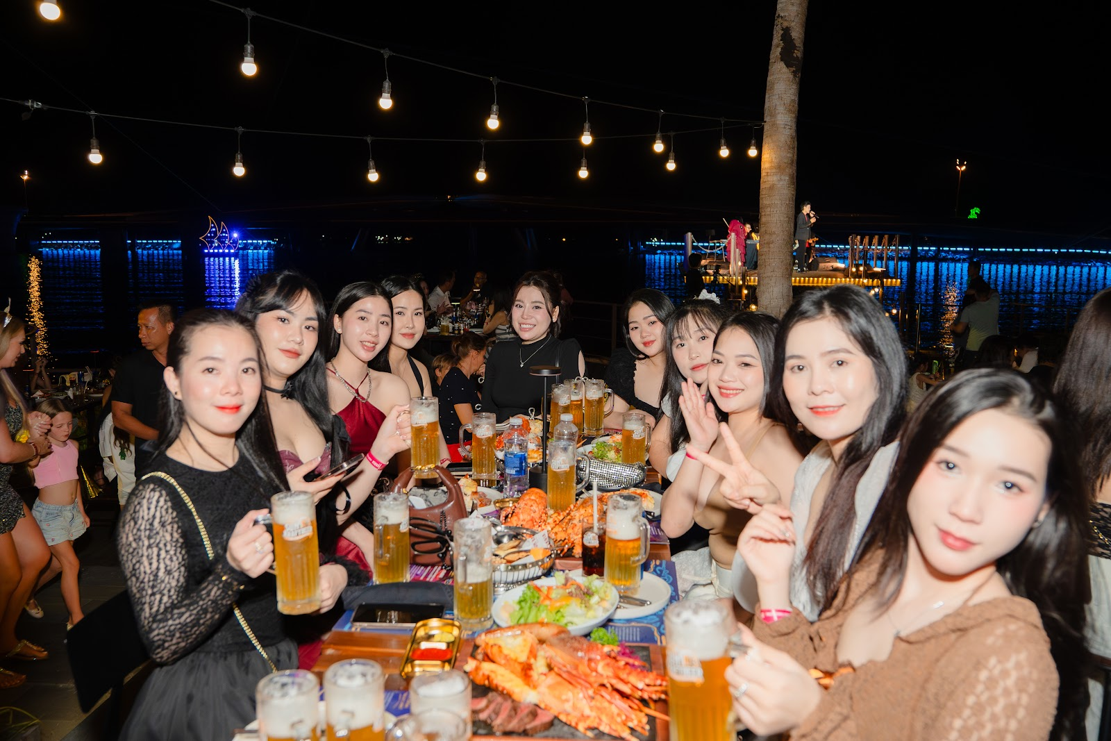 Du khách thưởng thức hương vị bia mát lạnh giữa không gian biển đêm.