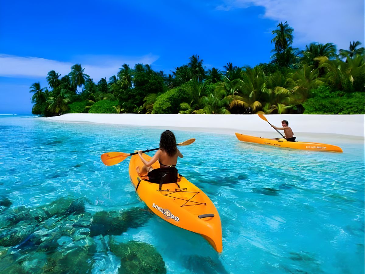 Du khách chèo kayak dọc biển Hòn Thơm, tận hưởng làn nước xanh biếc và khung cảnh biển đảo trong lành.