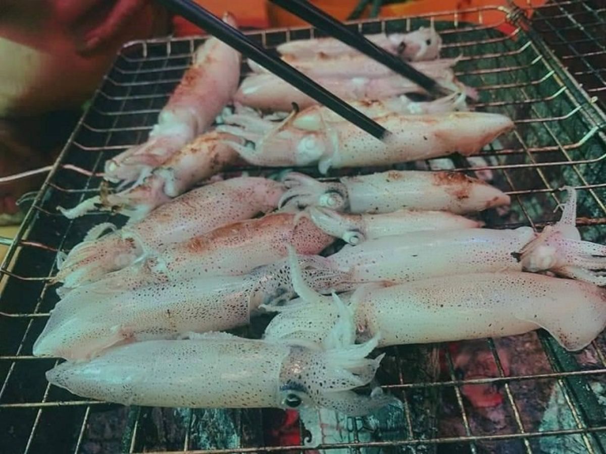 Du khách thưởng thức mực nướng tươi ngay trên tàu giữa không gian biển đêm