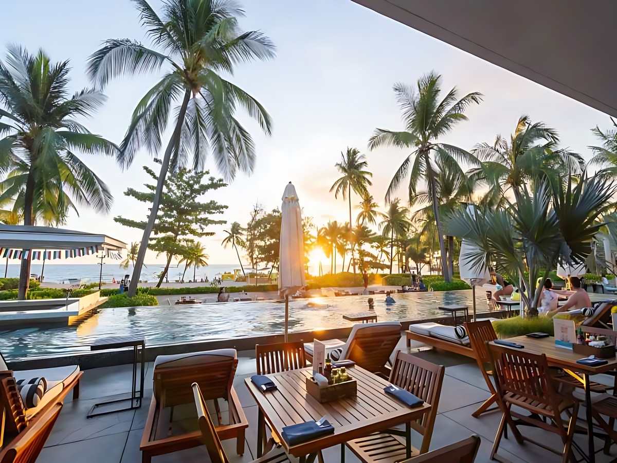 Du khách ngồi trên ghế lười tông cam ngắm cảnh biển tại OCSEN Beach Bar & Club
