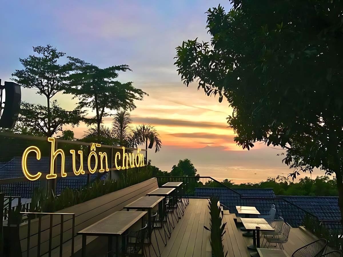 Du khách ngồi trên ghế lười tông cam ngắm cảnh biển tại OCSEN Beach Bar & Club