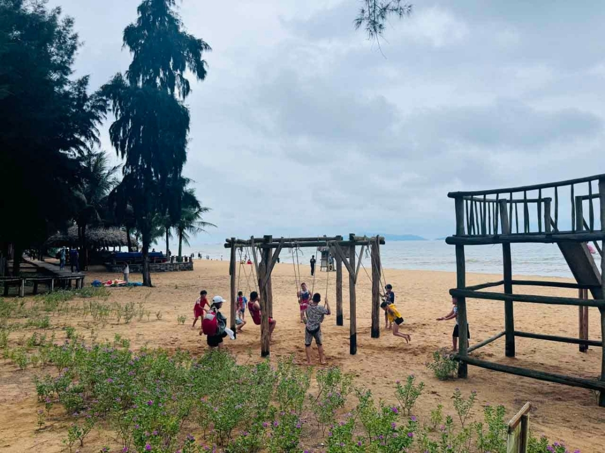 Du khách vui chơi trên bờ biển bãi Đông.