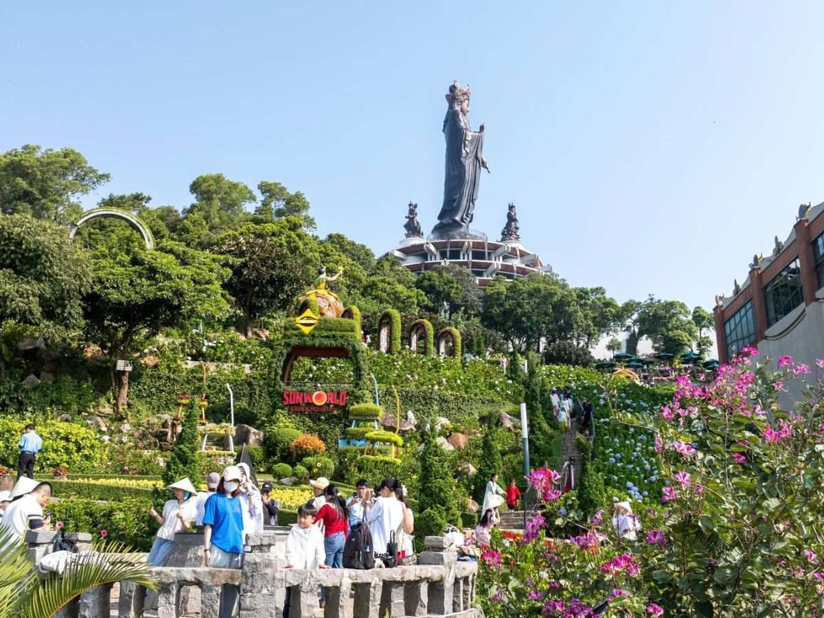 Du khách tham qua vườn hoa rực rỡ dưới chân tượng Phật Bà Tây Bổ Đà Sơn.