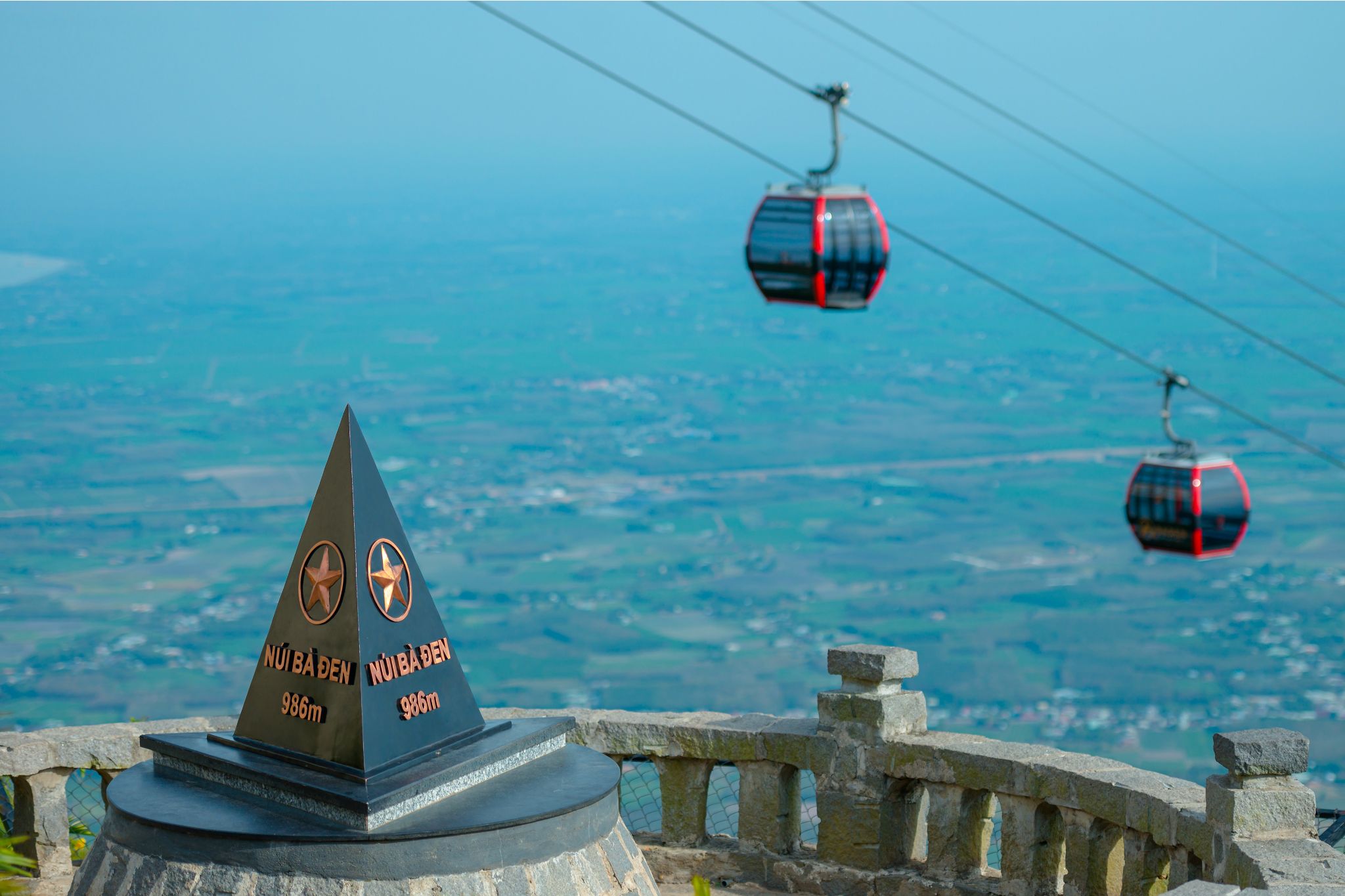 The Van Son cable car carries visitors above the plains toward the 986-meter peak