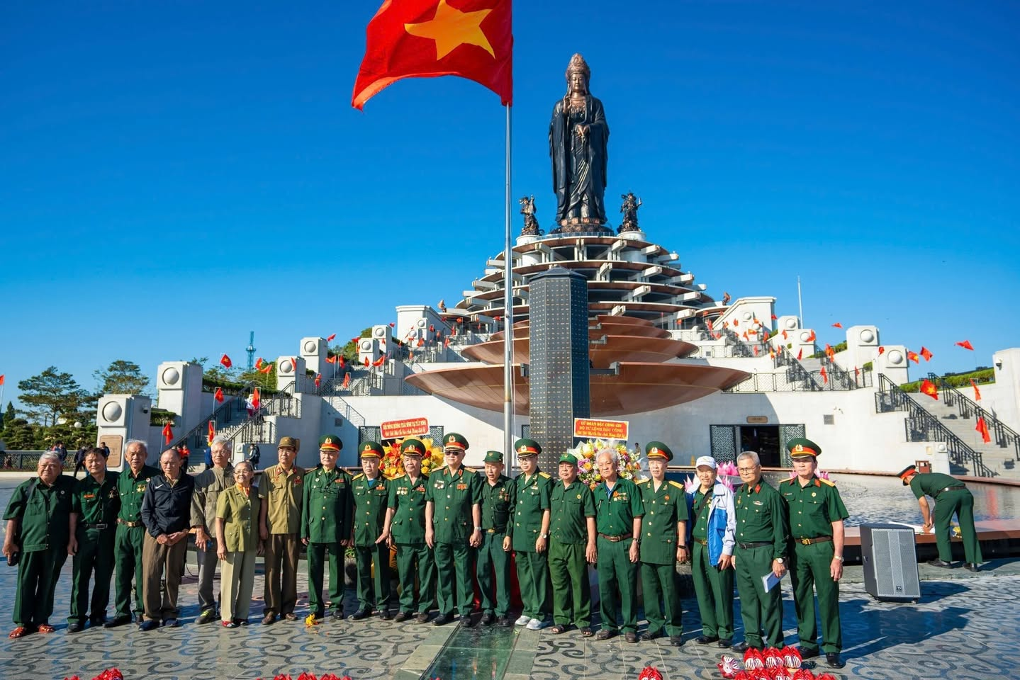 Đoàn các cựu chiến binh chụp ảnh kỷ niệm trước tượng Phật Tây Bổ Đà Sơn
