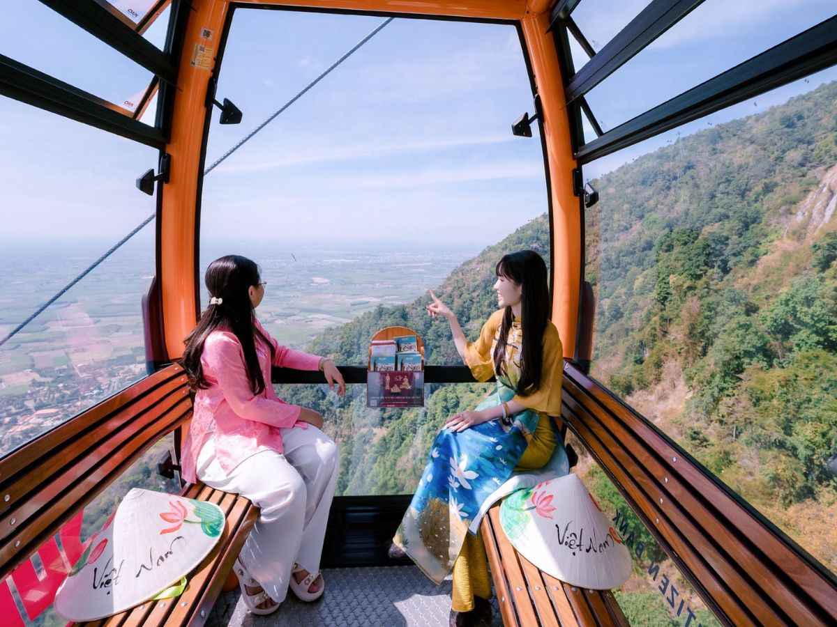 Du khách ngắm sườn núi và đồng bằng Tây Ninh từ cabin cáp treo.