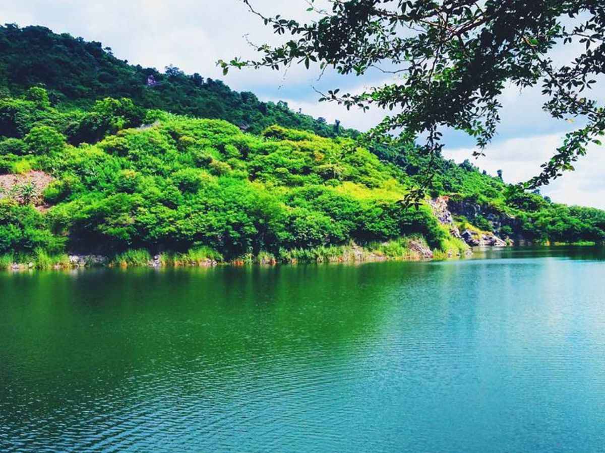 Mặt hồ xanh yên ả giữa những sườn đồi phủ kín cây rừng.