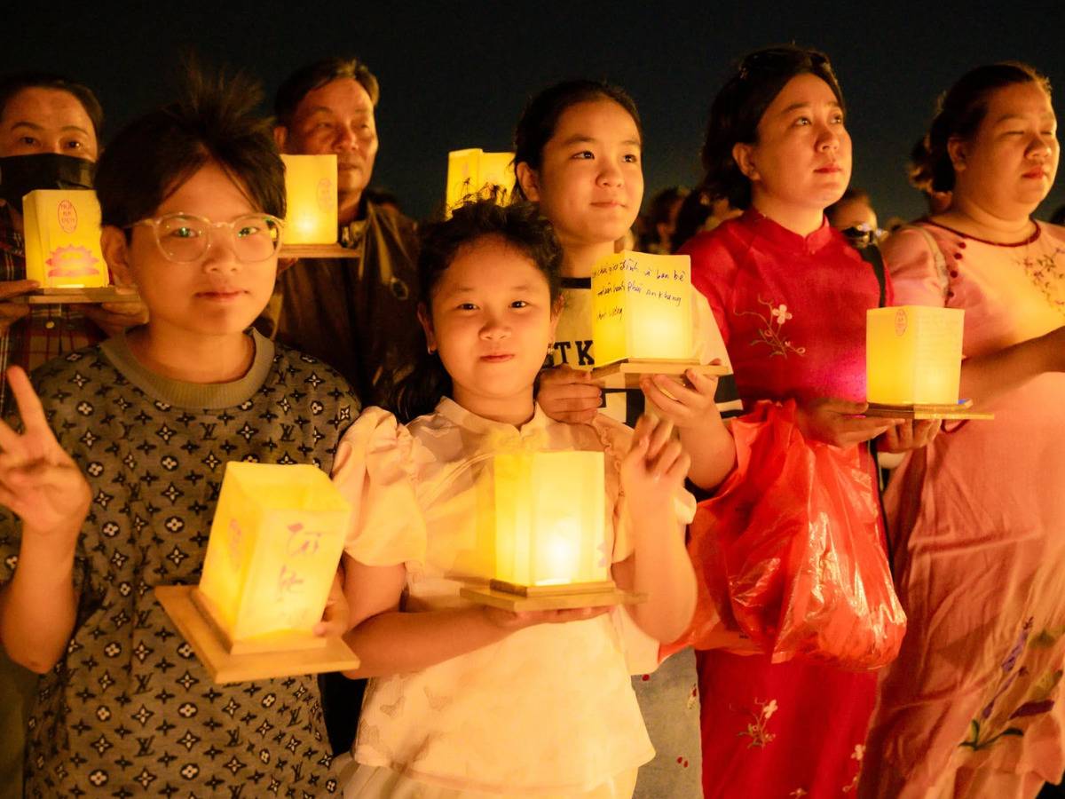 Gia đình quây quần bên nhau trong nghi thức thả hoa đăng lung linh.
