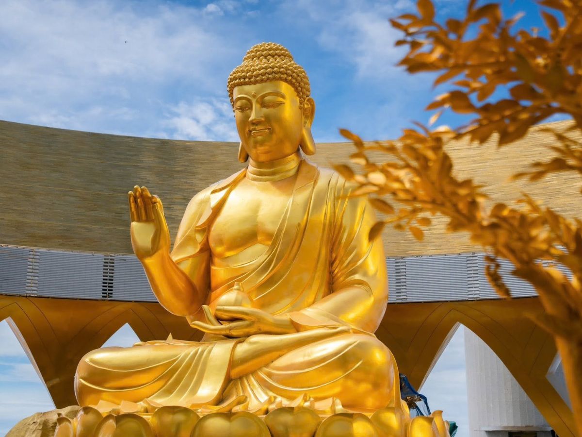 Tôn nghiêm tượng Phật Câu Na Hàm Mâu Ni màu vàng rực rỡ giữa không gian đỉnh núi.