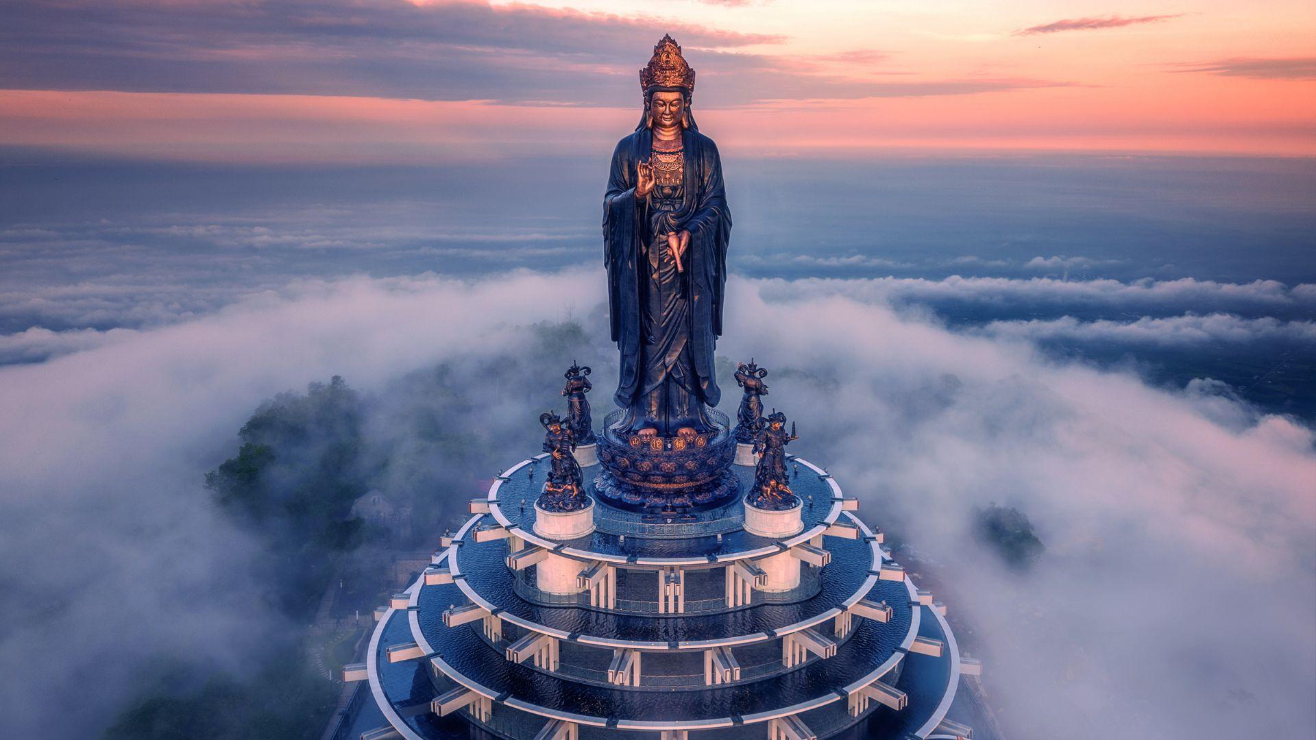 The majestic Lady Buddha statue of Tay Bo Da Son emerging through the floating sea of clouds atop Ba Den Mountain.