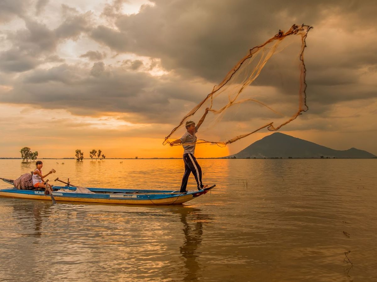 Ngư dân thả lưới trên Hồ Dầu Tiếng trong ánh hoàng hôn yên bình.