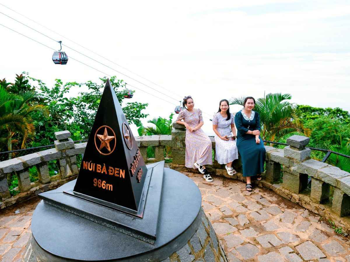 Du khách lưu lại khoảnh khắc bên cột mốc 986 m của Núi Bà Đen.