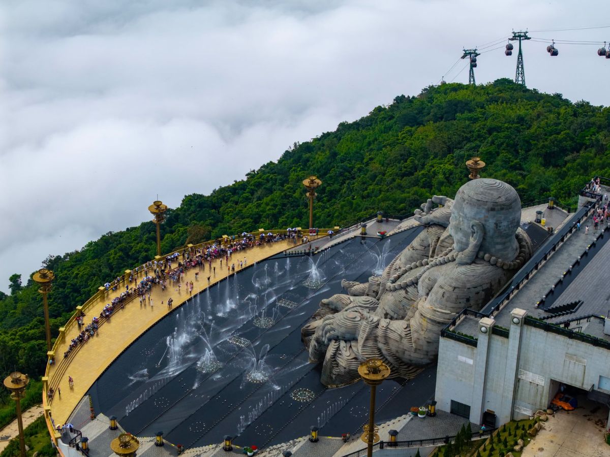 Tượng Phật Di Lặc nổi bật giữa thác nước và cảnh núi xanh trên Núi Bà Đen.