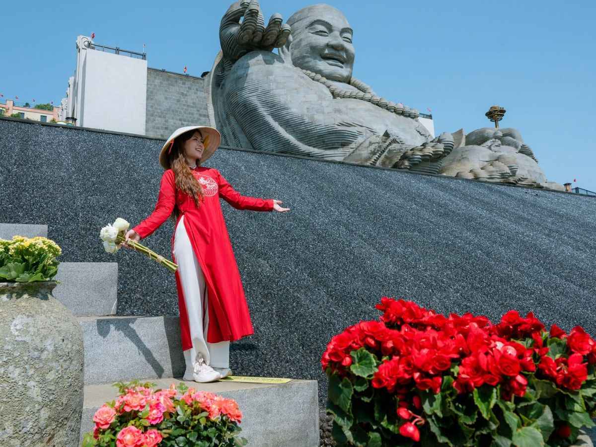 Du khách lưu lại khoảnh khắc bên tượng Di Lặc trên đỉnh Núi Bà Đen.