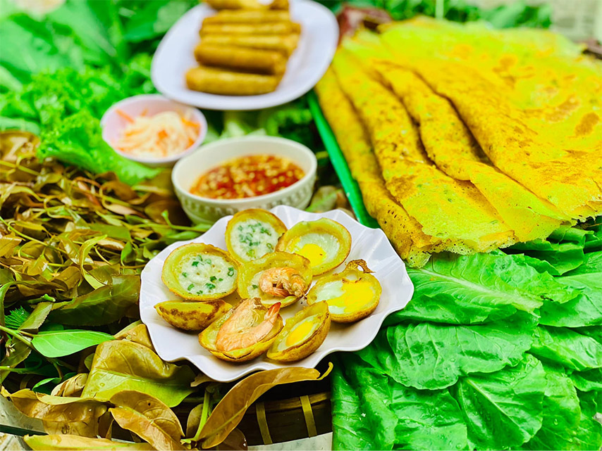 Bánh xèo, bánh khọt nóng hổi, giòn tan, cuốn với rau rừng càng thêm đậm đà hương vị (Nguồn: Internet)
