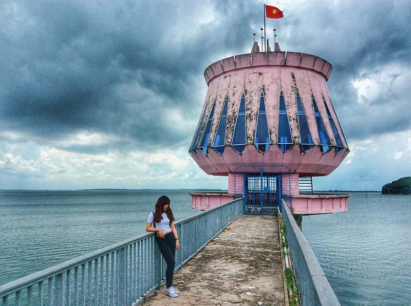 Du khách nữ chụp ảnh tại cây cầu dẫn tới ngọn hải đăng – địa điểm check in hồ Dầu Tiếng cực hot
